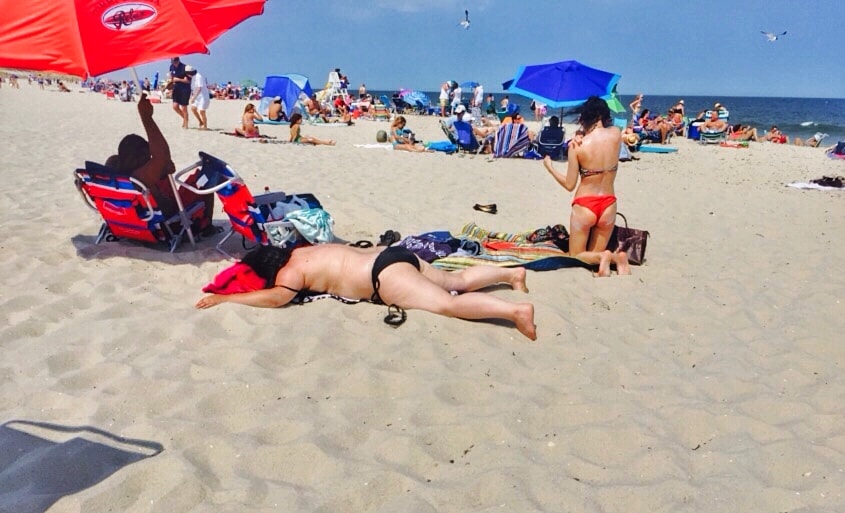 a person faced down on a towel at the beach